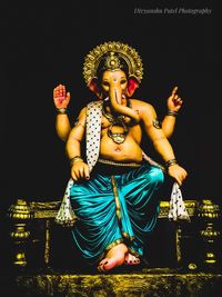 Statue of buddha against black background