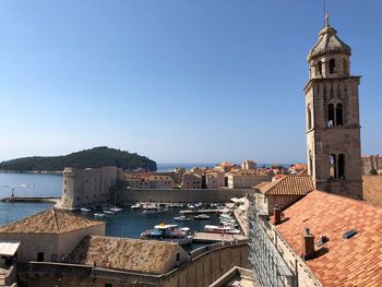 Panoramic view of buildings in city against clear blue sky