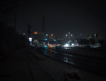 Illuminated city street and buildings at night