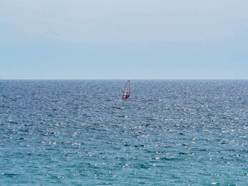 Sailboat in sea against clear sky