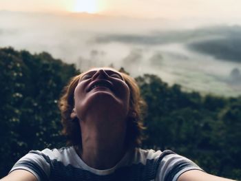 Close-up of woman with eyes closed against sky