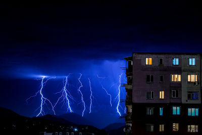 Low angle view of illuminated buildings against sky at night