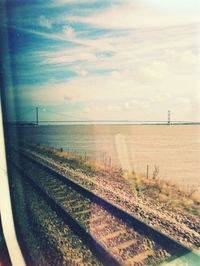 Railroad track against cloudy sky
