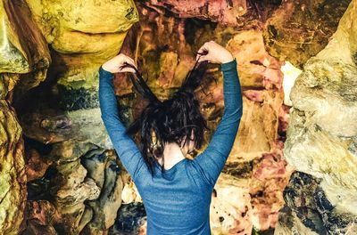 Rear view of woman standing against wall