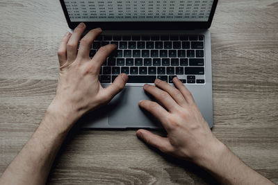 Cropped hands using laptop on table