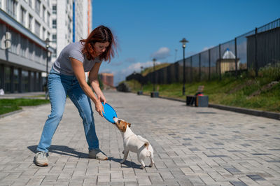 Man with dog on footpath in city