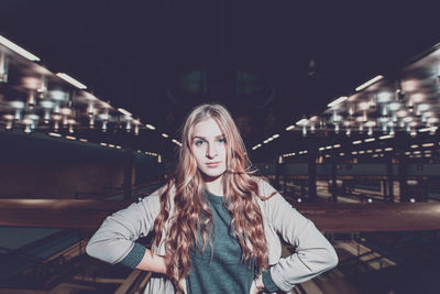 Portrait of a beautiful young woman standing at night