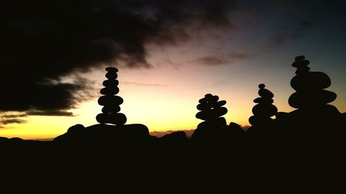 Silhouette cross against sky during sunset