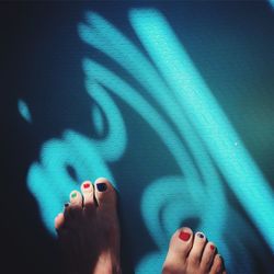Low section of woman legs in blue shadow