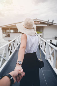 Rear view of woman on bridge against sky