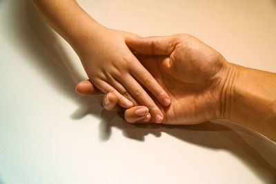 Cropped hand of woman holding child