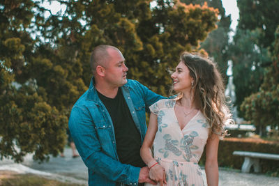 Couple embracing against trees