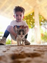 Portrait of cute boy with kitten outdoors