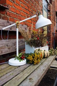 Lamp by flowers on wooden table at yard