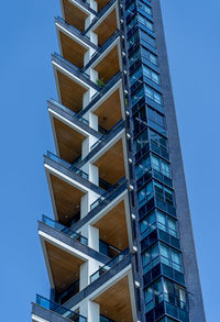 Low angle view of modern building against clear blue sky