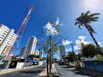 Street amidst buildings against clear blue sky