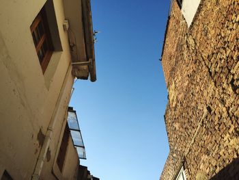 Low angle view of old building against clear blue sky