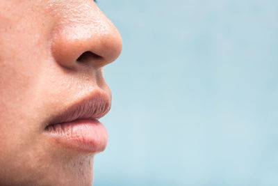 Cropped image of woman sweating by blue background