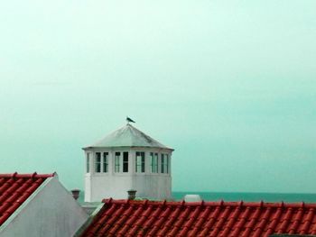 High section of house by sea against clear sky