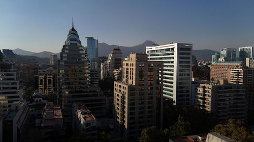 Buildings in city against clear sky