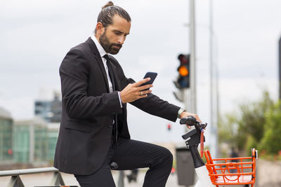 Full length of man riding bicycle on mobile phone