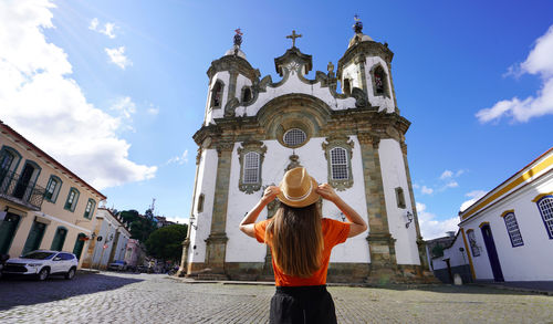 Tourism in brazil. rear view of young traveler woman visiting sao joao del rei, minas gerais, brazil