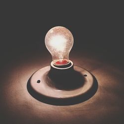 Close-up of illuminated lamp on table