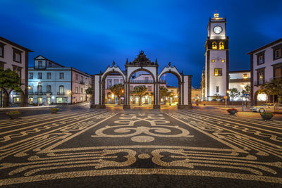 View of illuminated street amidst buildings at night