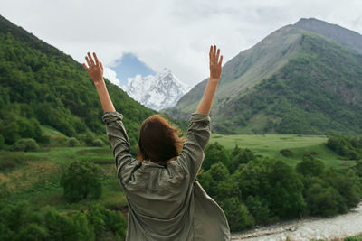 Rear view of man on mountain against sky