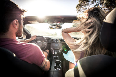 Rear view of couple sitting in car