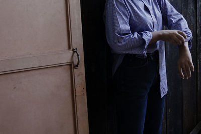 Midsection of woman standing by door