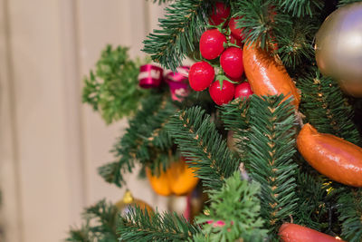 Christmas and new year  background. christmas tree with artificial sausagws, tomatoes and balls
