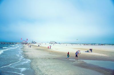 People on beach against clear sky