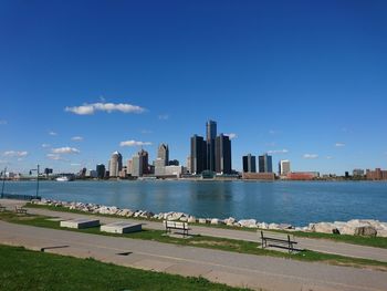 Sea by city buildings against sky