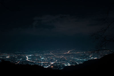 Illuminated cityscape against sky at night