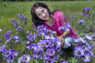 Woman with purple flowers on field