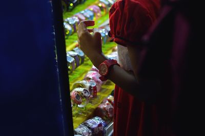 Cropped image of girl standing by watches in store