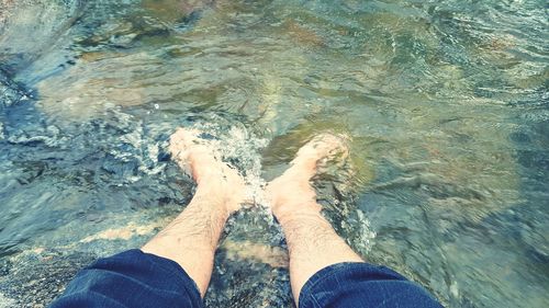 Low section of man standing in water