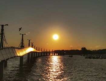 Silhouette bridge against sky during sunset