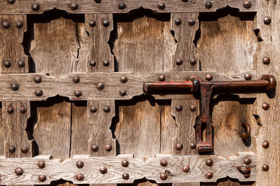 Antique decorated door with wood carving and metal details, wooden background