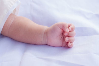 Close-up of baby hand on bed