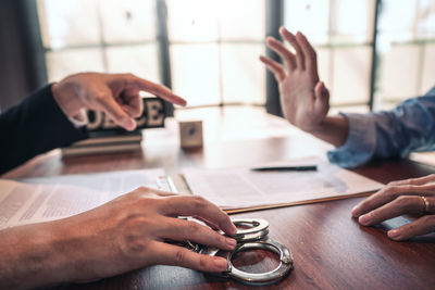 Midsection of man using smart phone on table