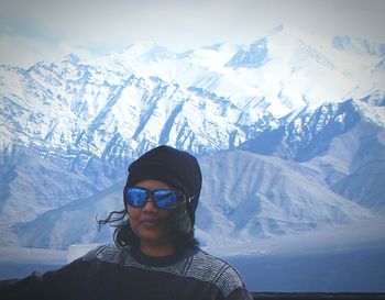 Portrait of young woman in mountains against sky