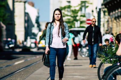Full length of woman walking on footpath in city