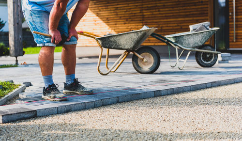 Low section of construction worker standing on paving stones