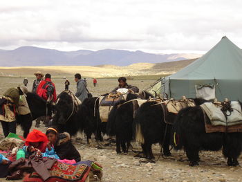 Group of people on mountain against sky