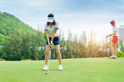 Rear view of women standing on golf course