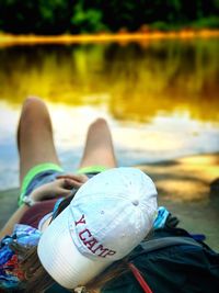 Woman with cap resting at lakeshore