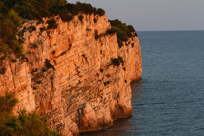 Rock formations by sea against sky