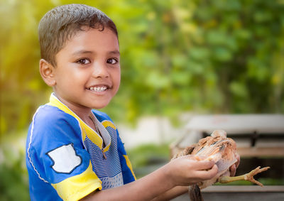 Portrait of cute boy holding chick